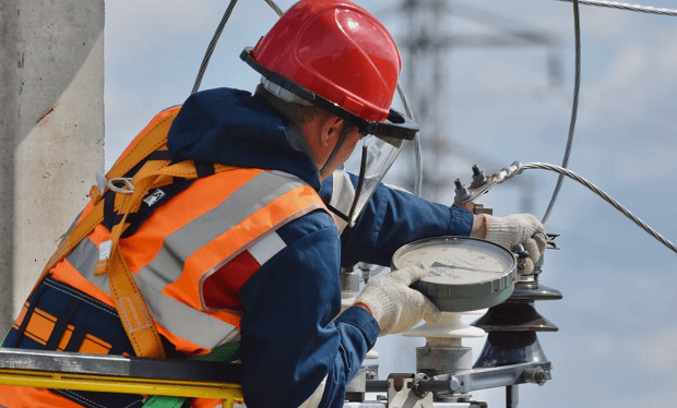 electrician installing hardware on pole