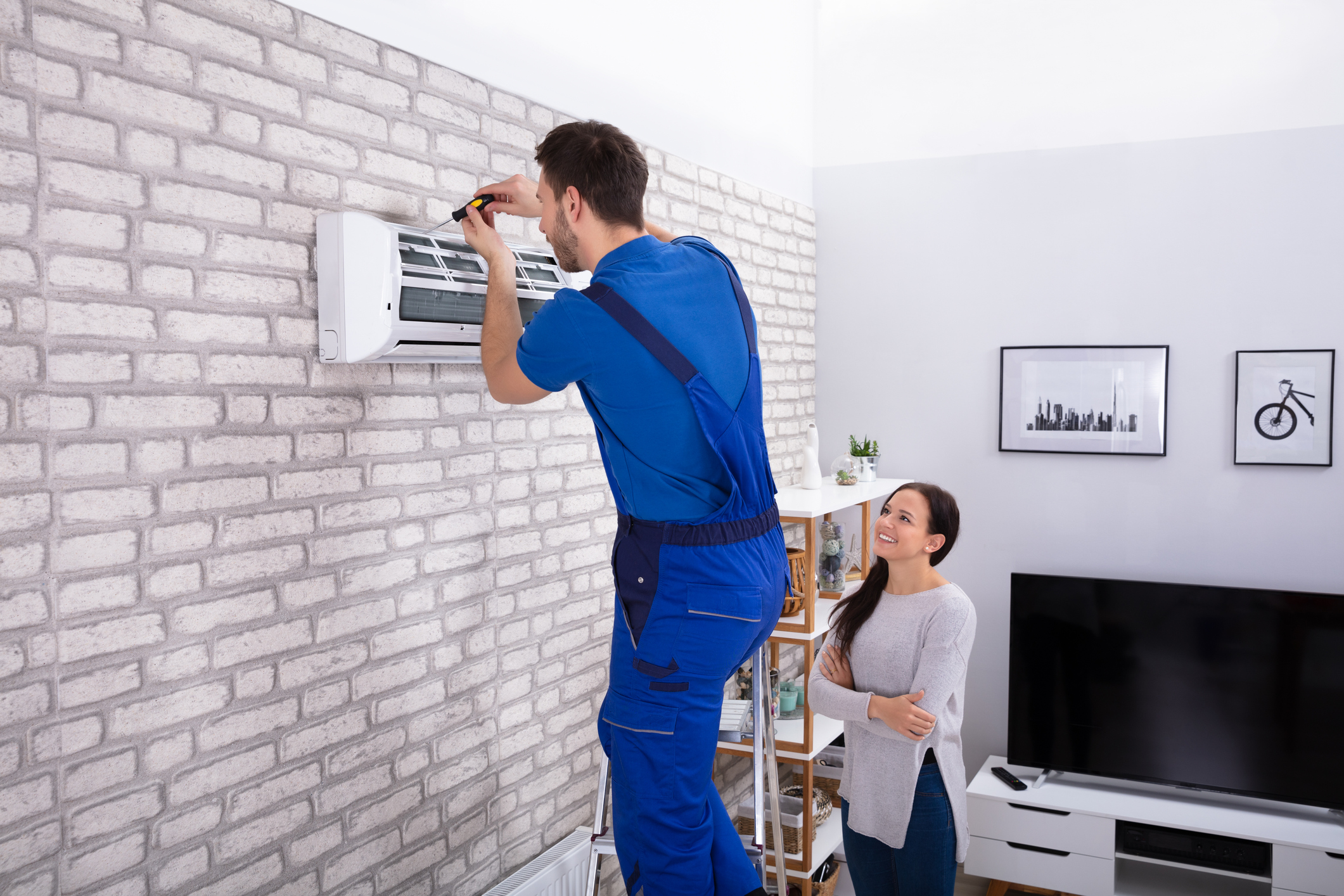 Male Technician Repairing Air Conditioner With Screwdriver
