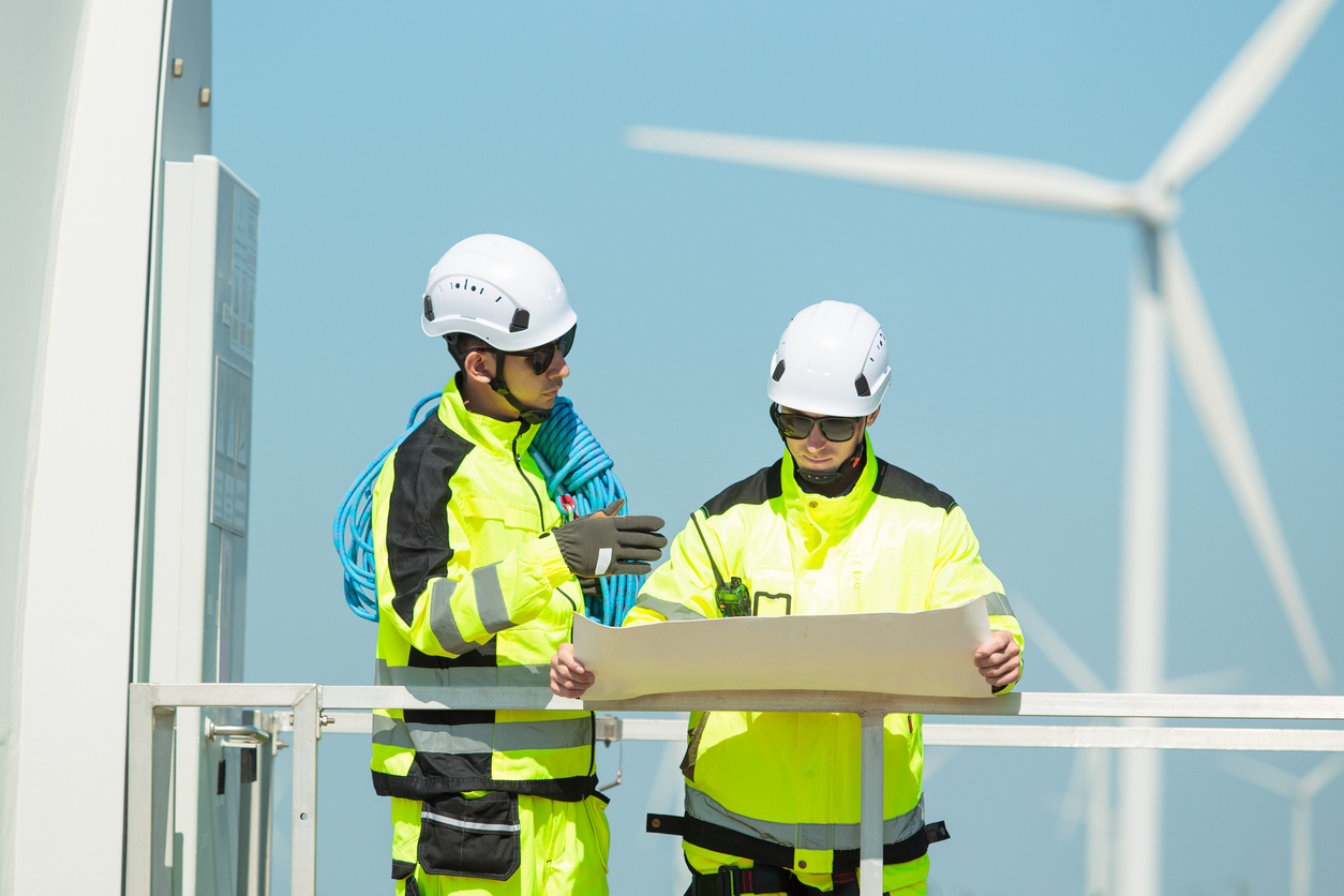 Engineers working on windmill turbine generator site.