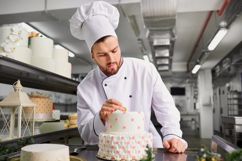Confectioner with a cake in the bakery