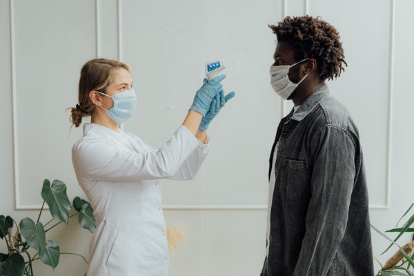 licensed practical nurse taking patient temperature