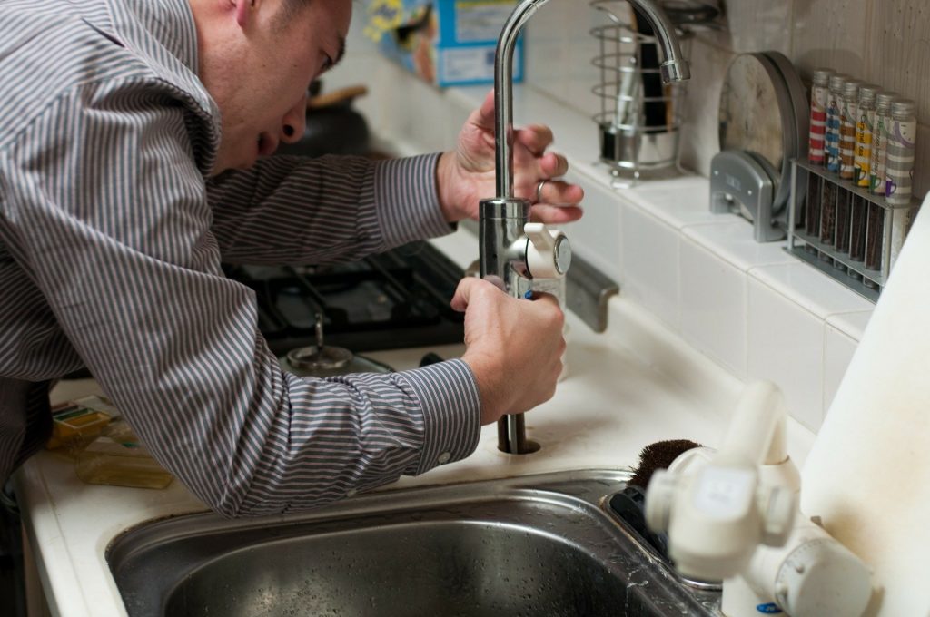 residential plumber repairing a faucet