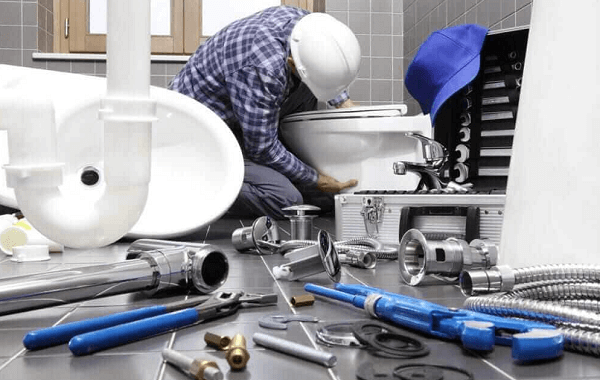 plumber installs a toilet